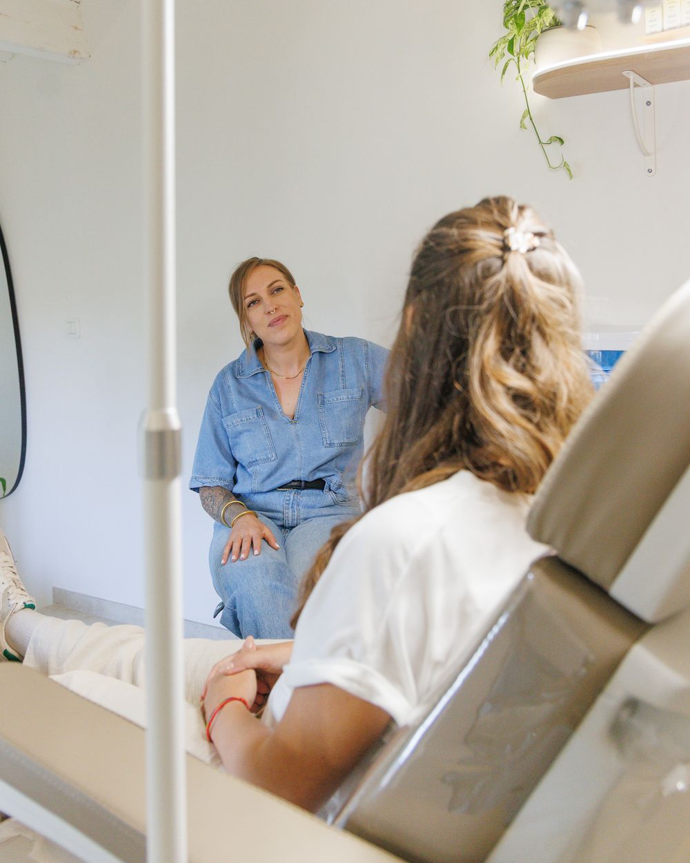 Marie échange avec une cliente installée dans le fauteuil de soin, au studio Hylé