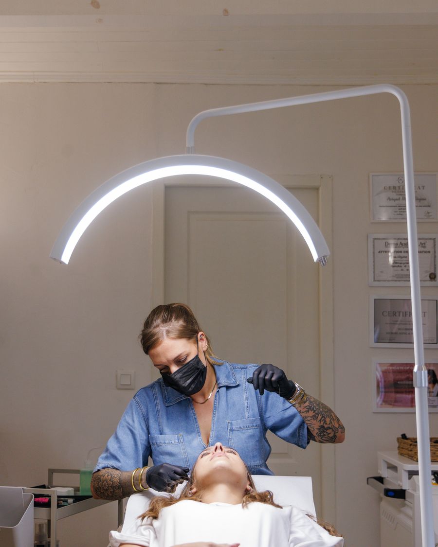 Marie réalise un maquillage permanent sous la lampe de la cabine Hylé à Biguglia
